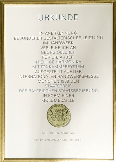 Urkunde: Staatspreis der Bayerischen Staatsregierung 1989 für Georg Öllerer — 4-reihige Harmonika mit Tonkammersystem, Goldmedaille